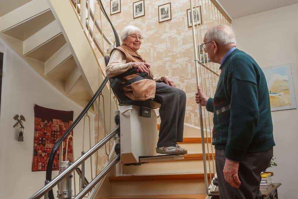 Älteres Paar an einer Treppe mit Treppenlift