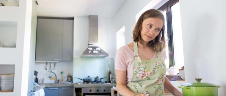 Junge Frau kocht in einer Miniküche