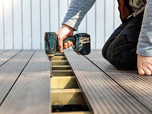 Ein Heimwerker baut eine WPC Terrasse